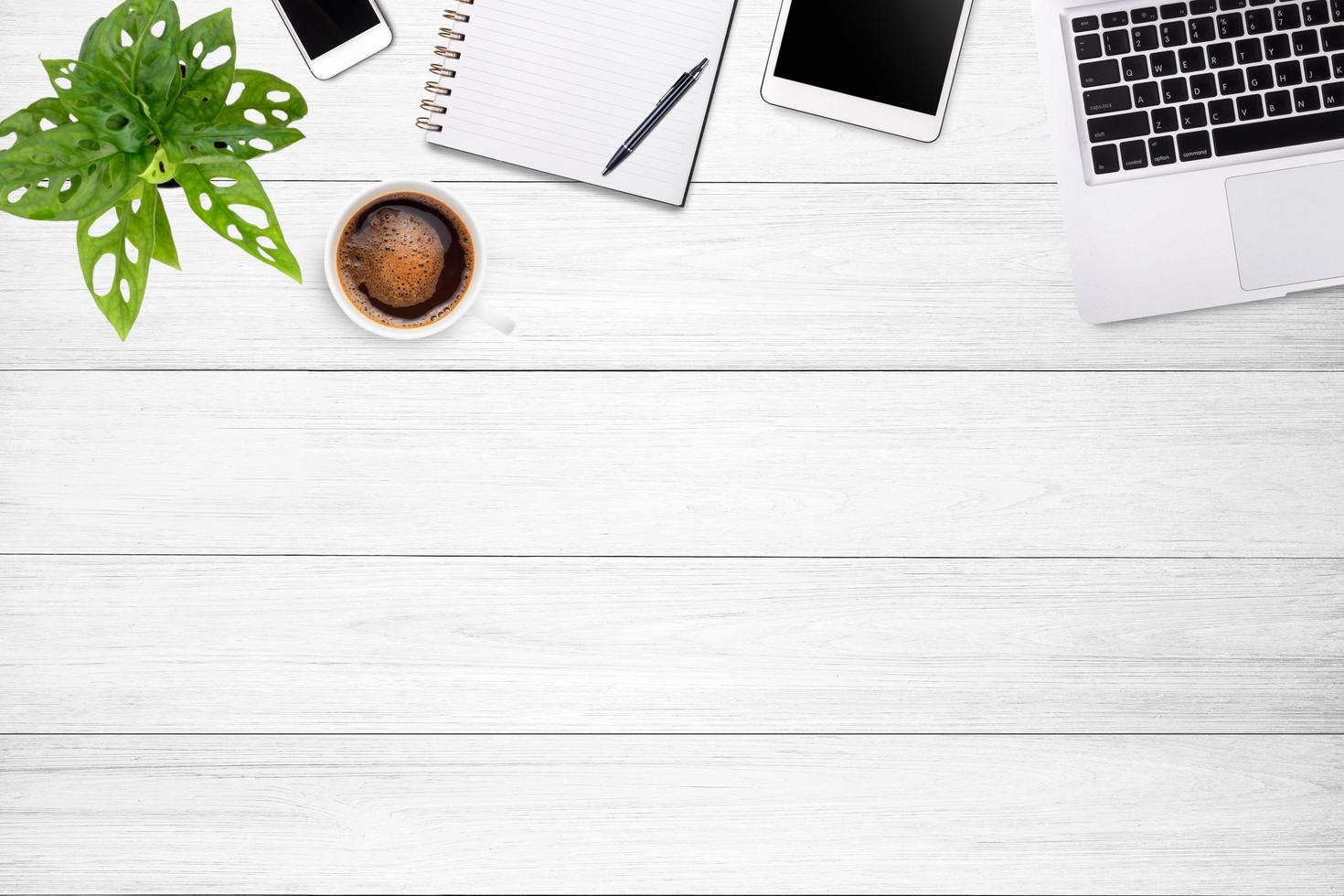 Modern workspace with laptop tablet, smartphone and coffee cup copy space on white wood table background. Top view. Flat lay style. photo