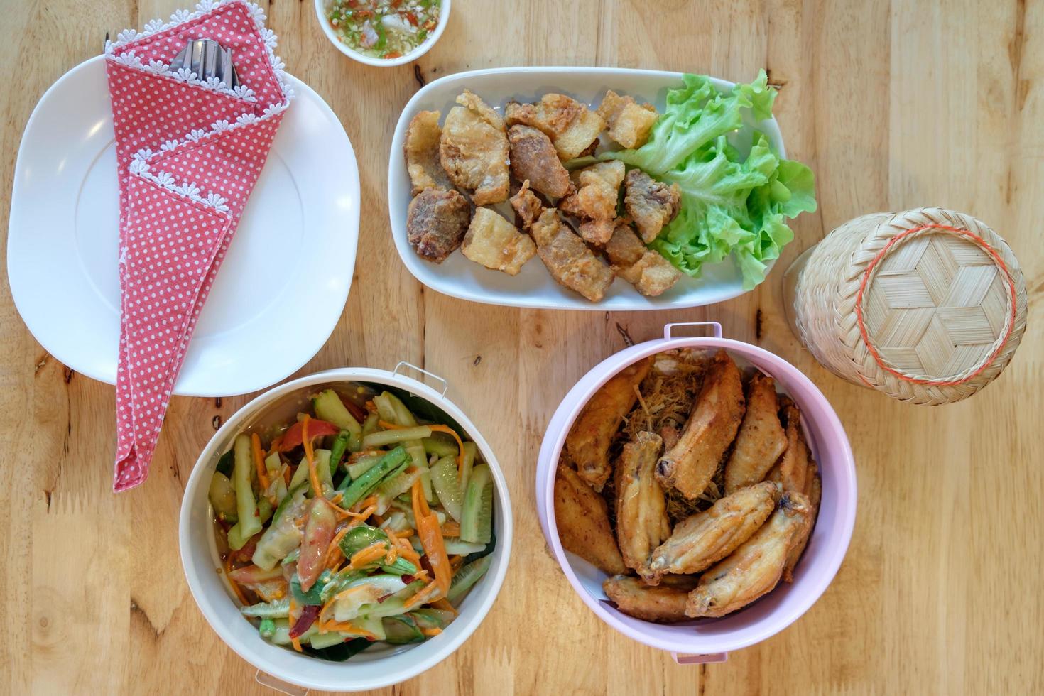Top view of papaya salad  with consists of grilled chicken, fried pork photo