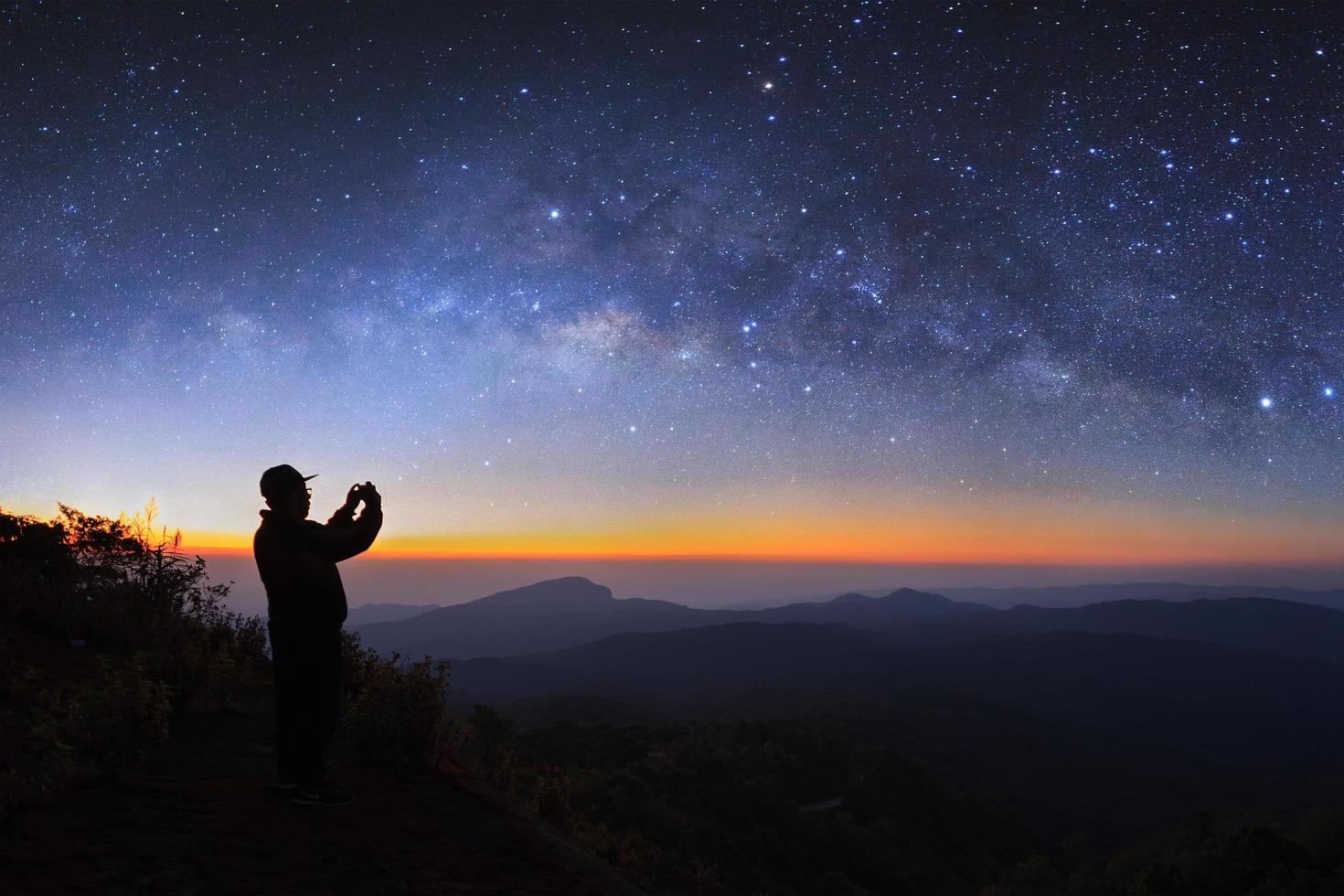 A man take photo milky way galaxy at Doi inthanon Chiang mai, Thailand. Long exposure photograph. With grain