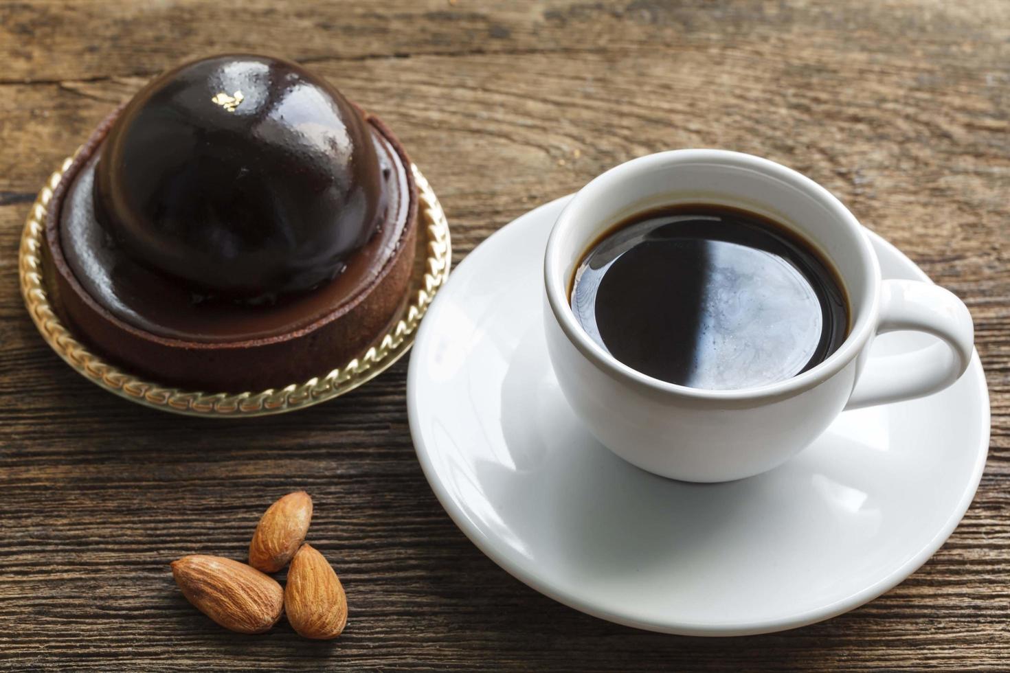 Coffee with chocolate cake and almonds on wood background photo