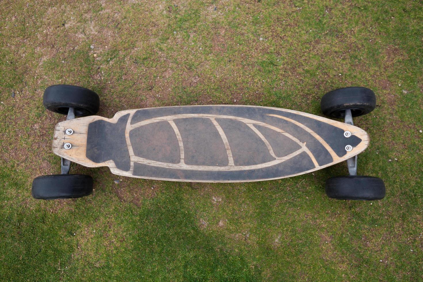Old wooden skateboard on grass photo