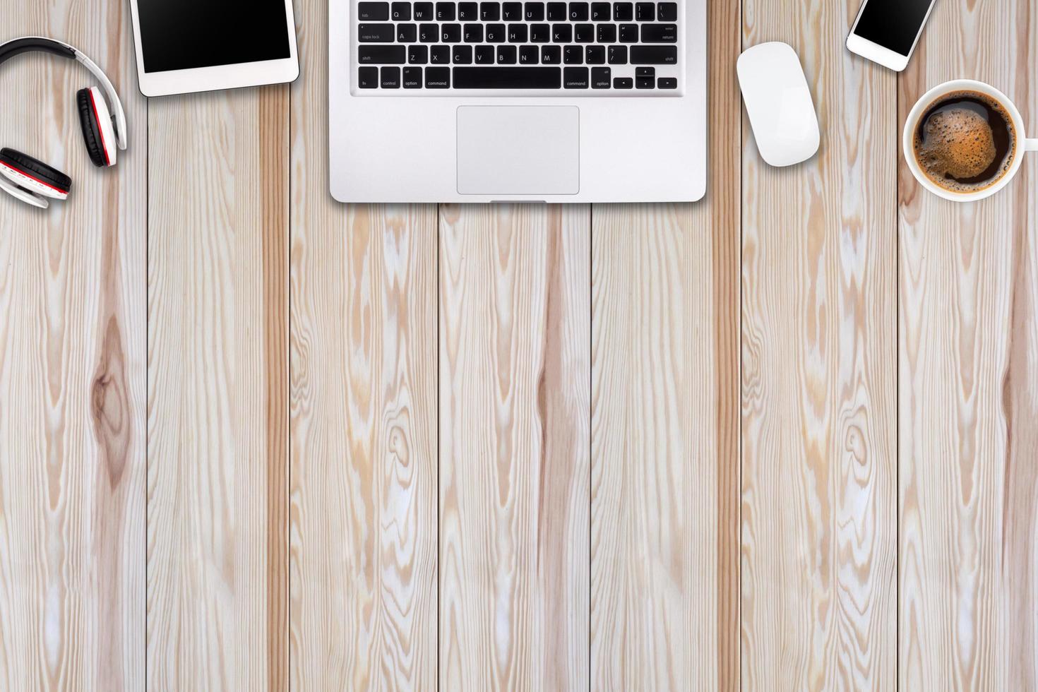 Modern workspace with laptop tablet, smartphone and coffee cup copy space on wood background. Top view. Flat lay style. photo