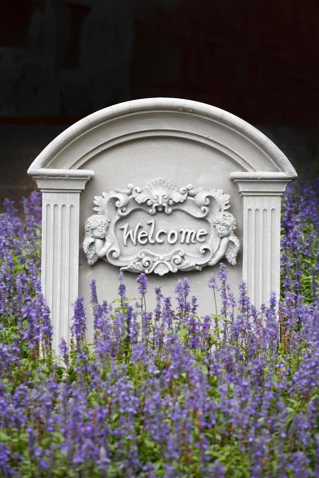 Welcome sign on stone background with lavender flower photo