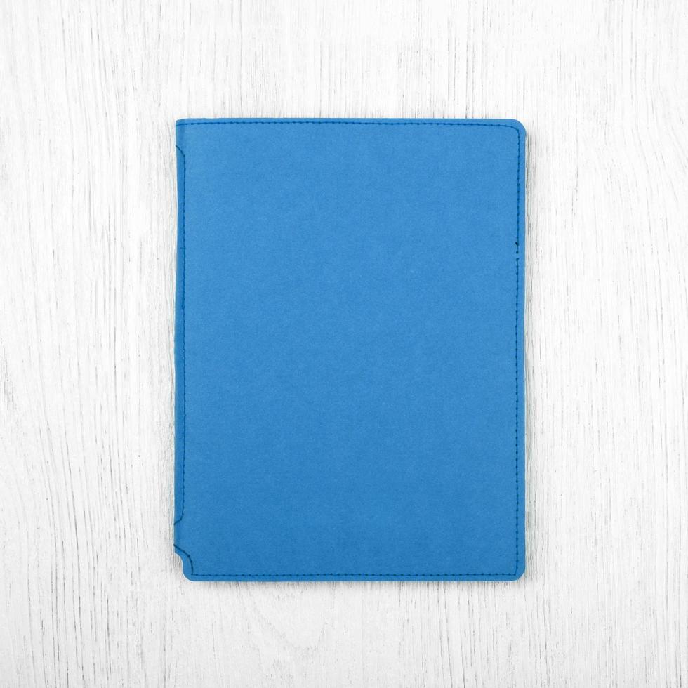 cuaderno azul sobre mesa de madera blanca, vista superior foto