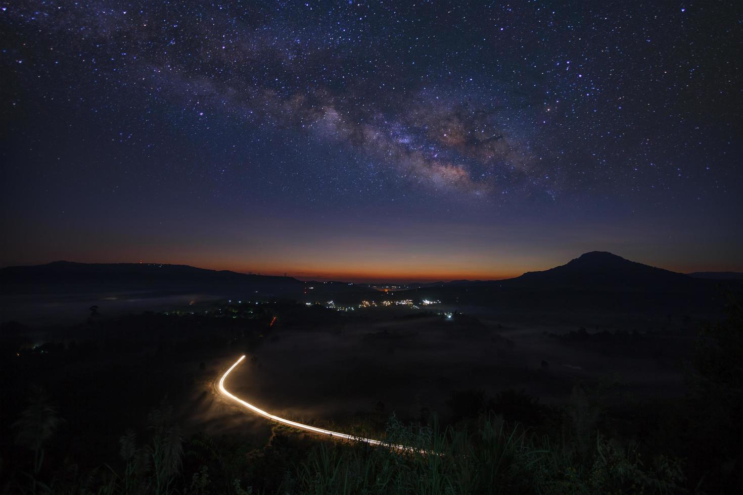 Milky Way Galaxy with lighting on the road. Long exposure photograph.With grain photo