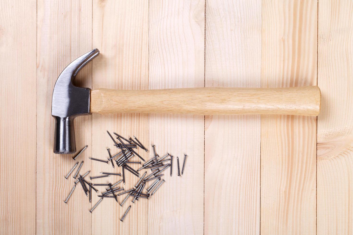 hammer with nail on wood background photo