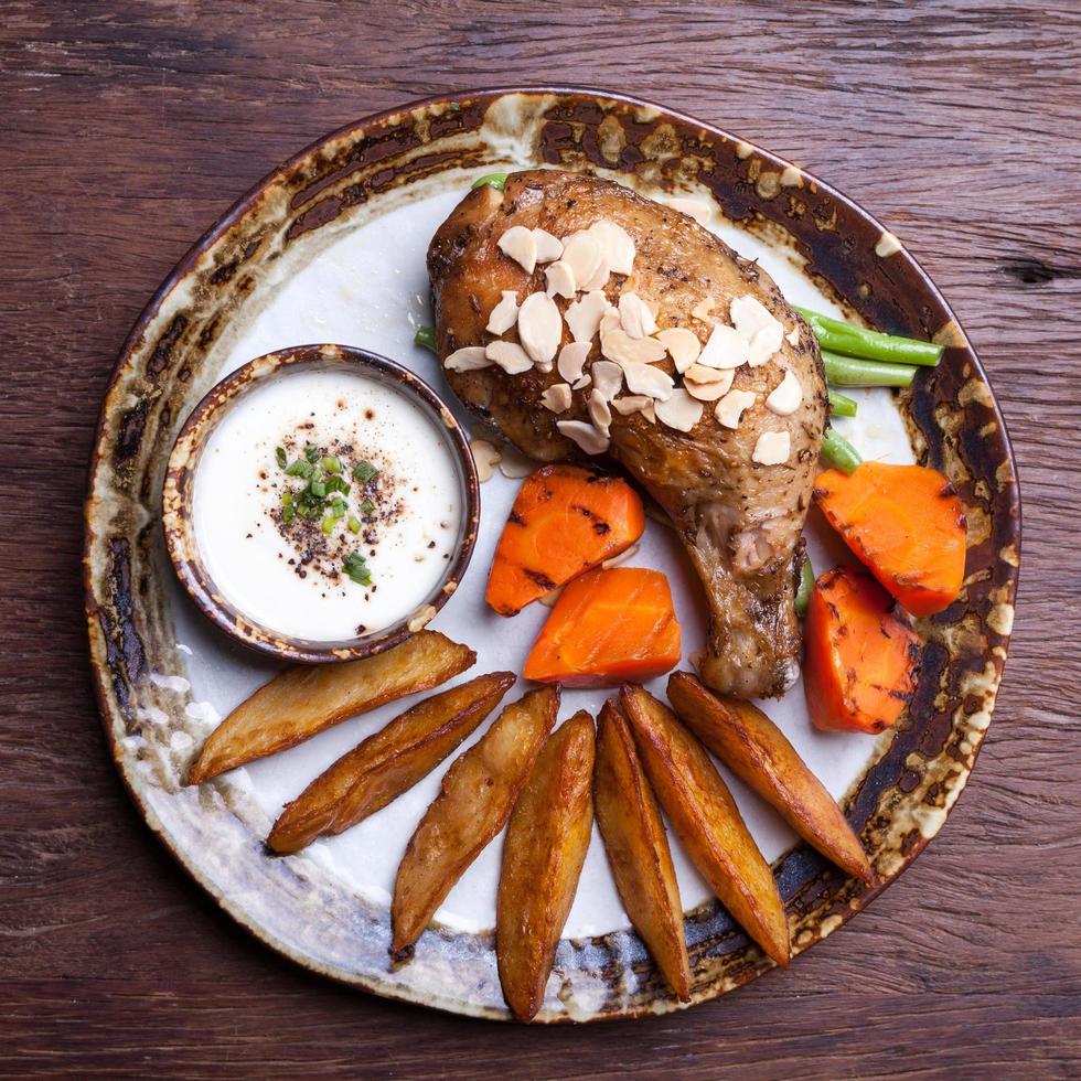 fried chicken drumsticks with  potato wedge,carrot on plate photo