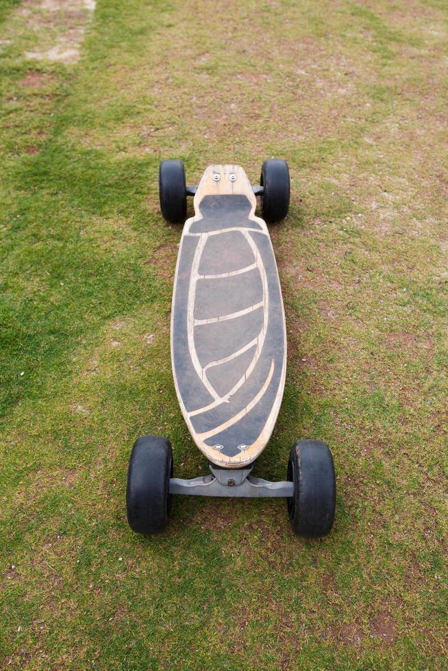 Old wooden skateboard on grass photo