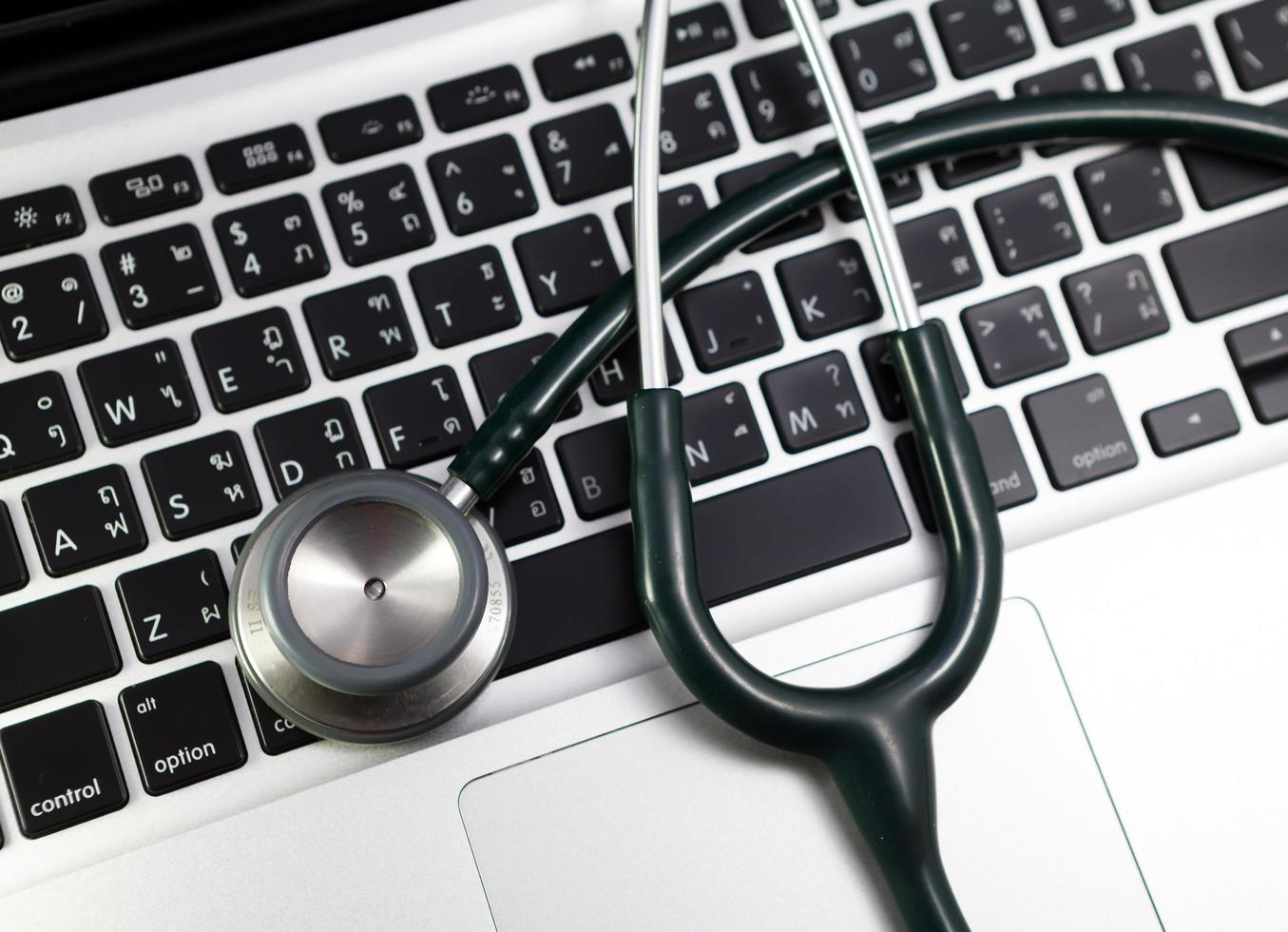 stethoscope on keyboard laptop photo