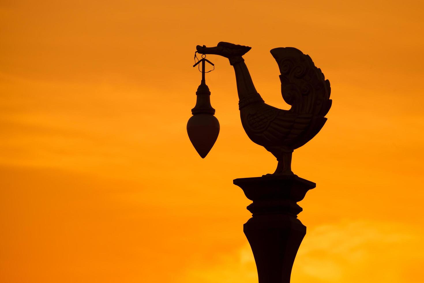 Silhouette, sculpture of golden swan light pole photo