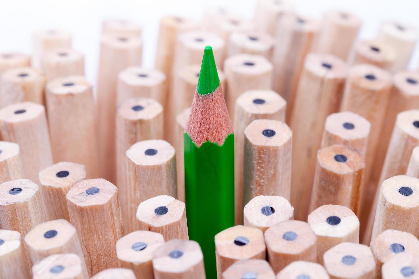One sharpened green pencil among many ones photo