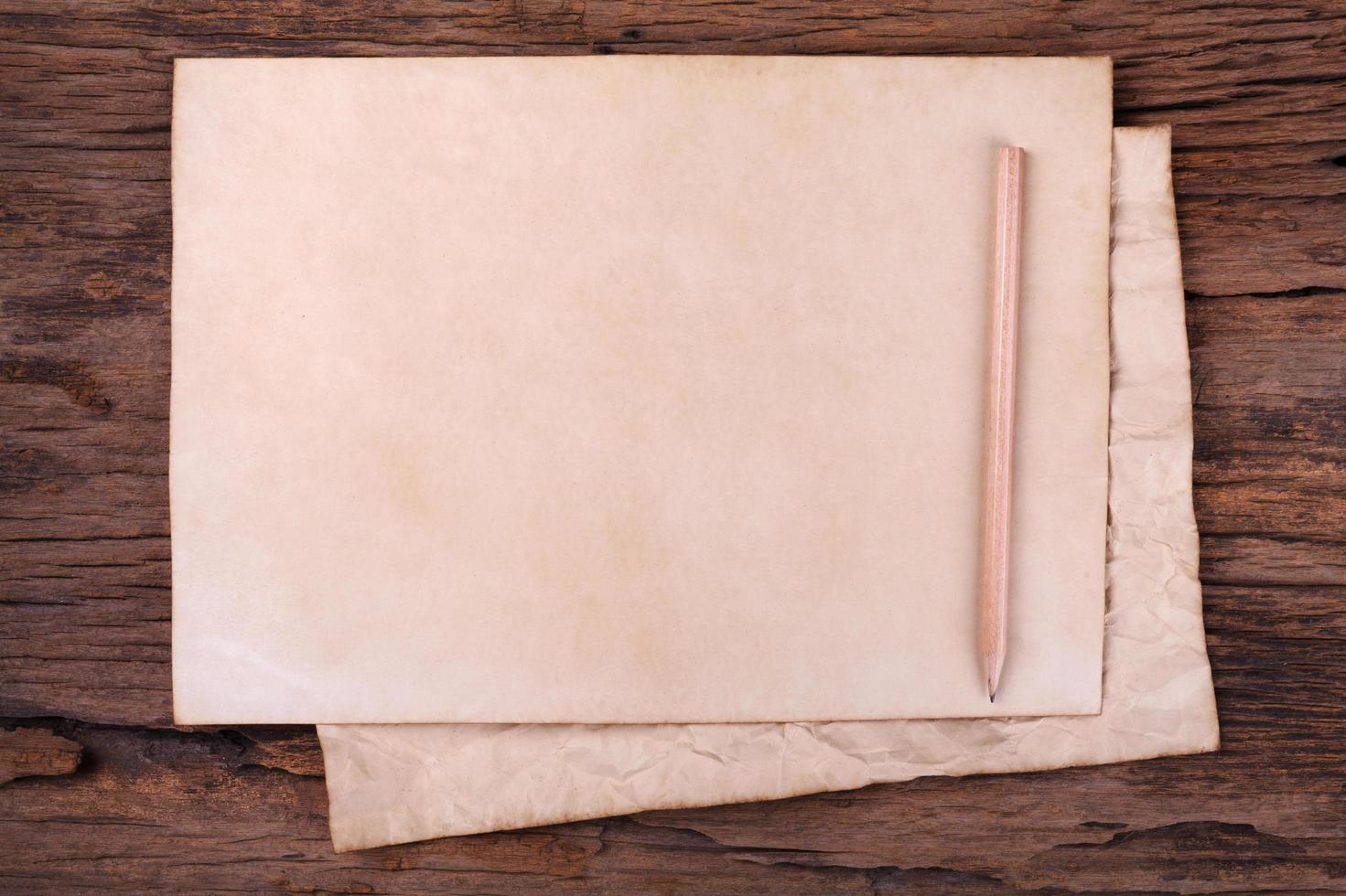 Old paper with  pencil on wooden table photo