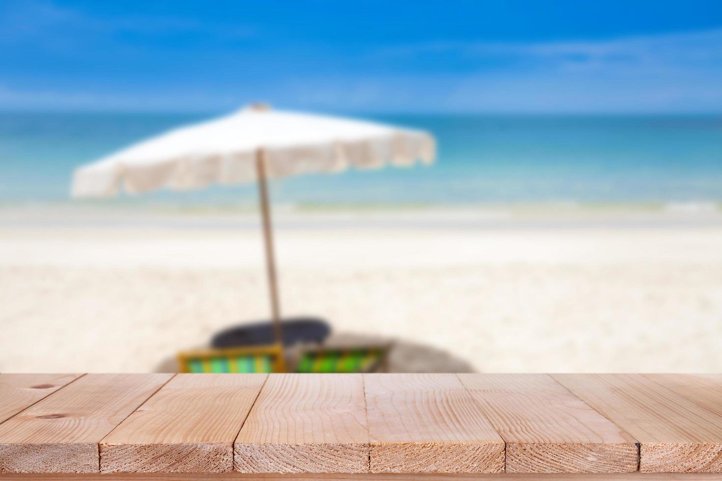 Wood table top on blurred blue sea and white sand beach background photo