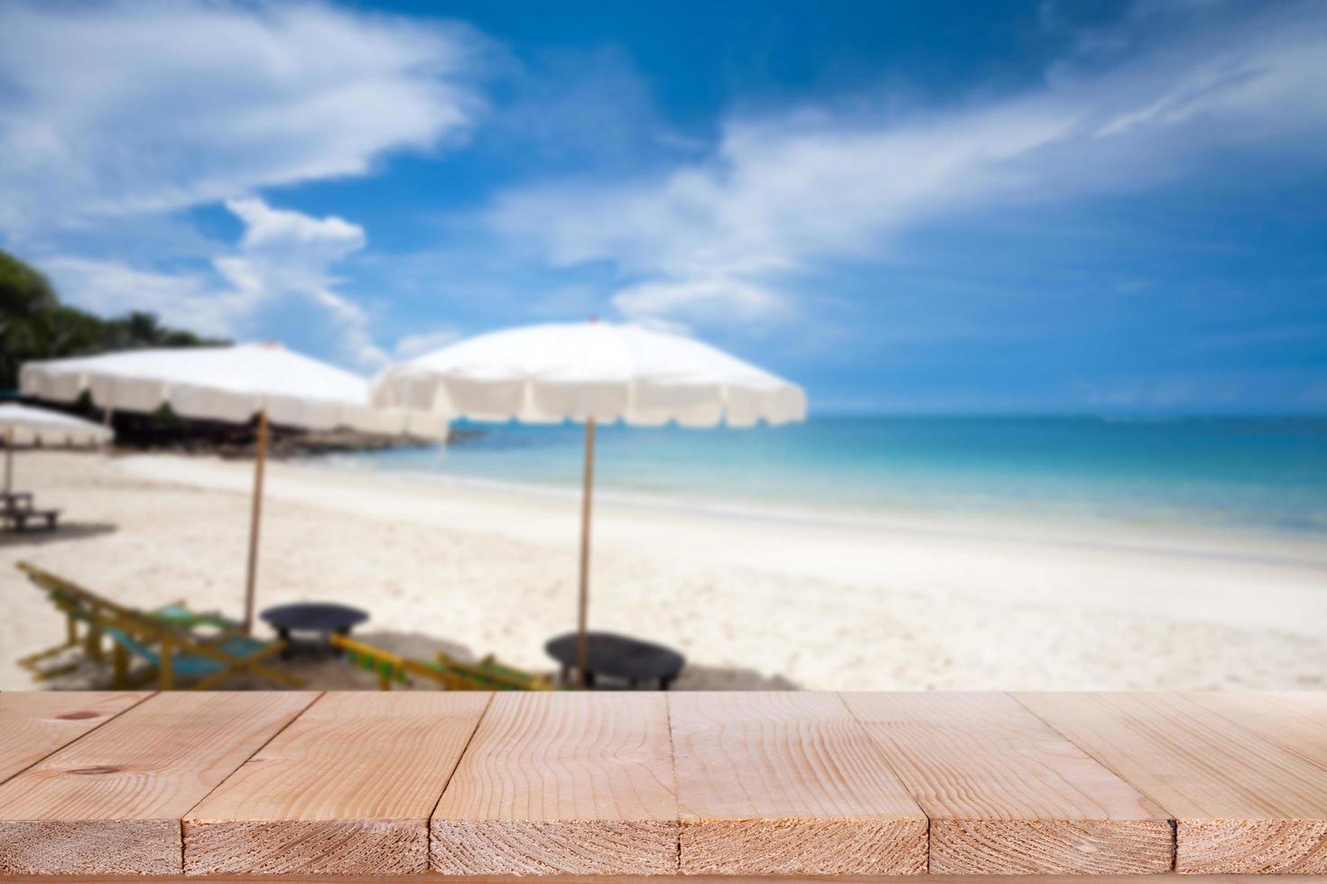 Wood table top on blurred blue sea and white sand beach background photo
