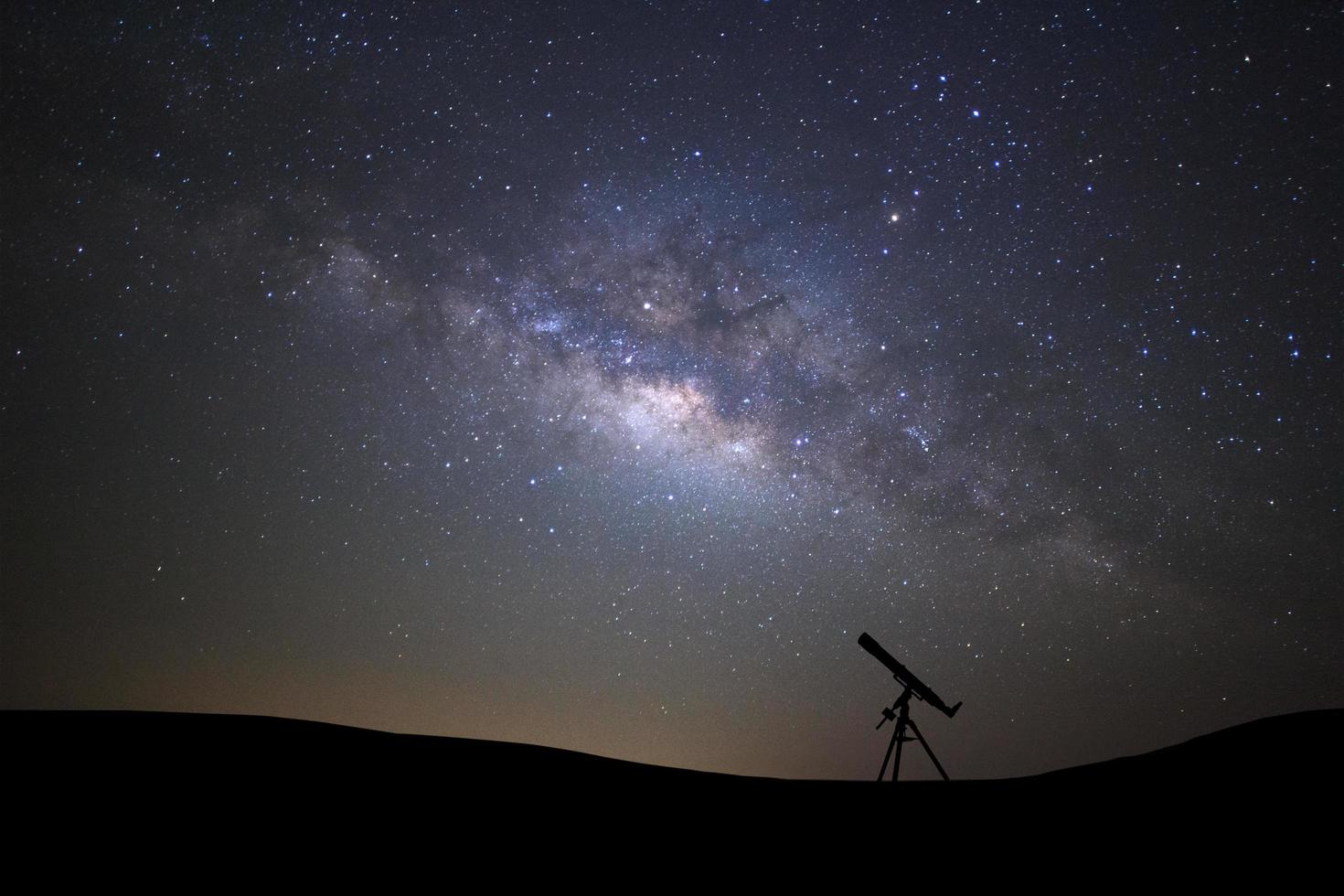 Silhouette of telescope watching the wilky way galaxy with stars and space dust in the universe photo