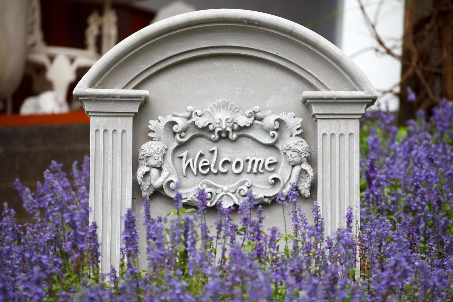 Welcome sign on stone background with lavender flower photo