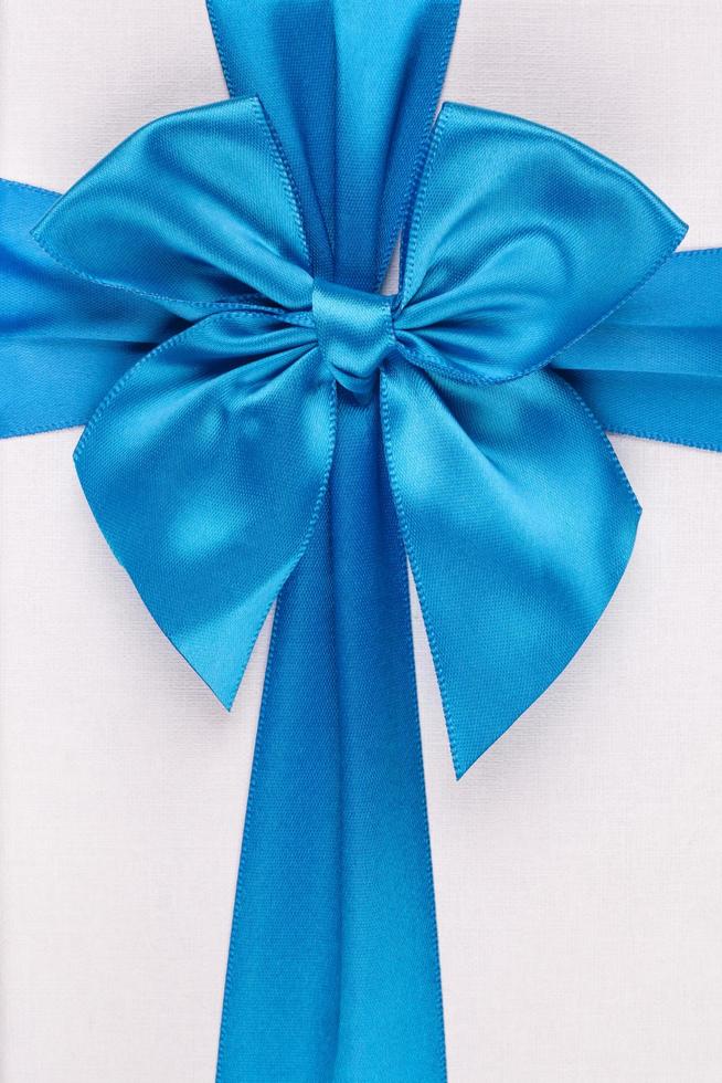 Blue ribbon with bow as gift on white background photo