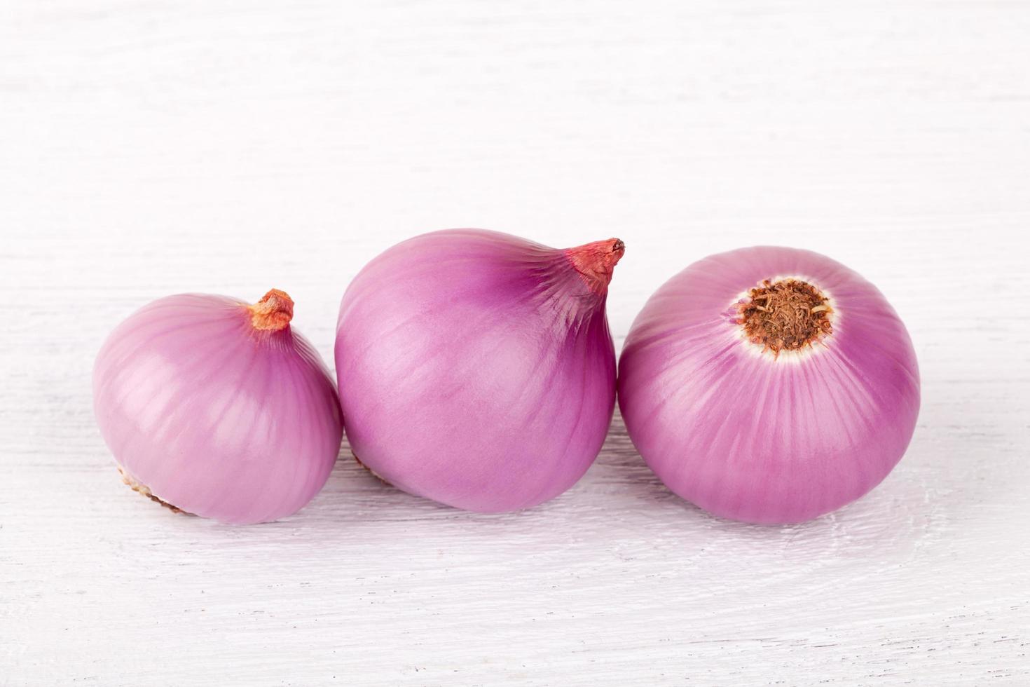 red onion bulb on white wood photo