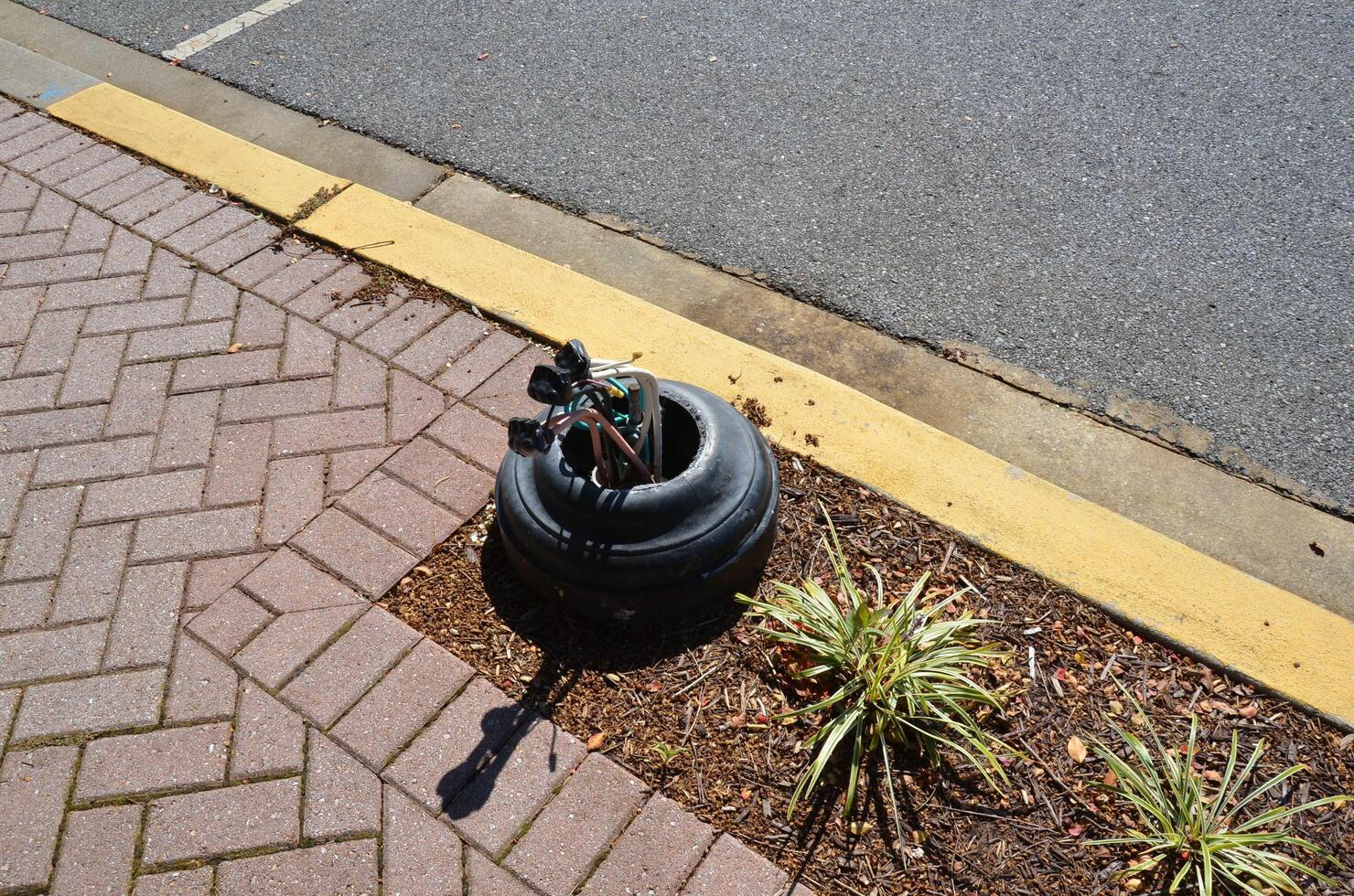 broken lamp post with electrical connections on side of road 11044940