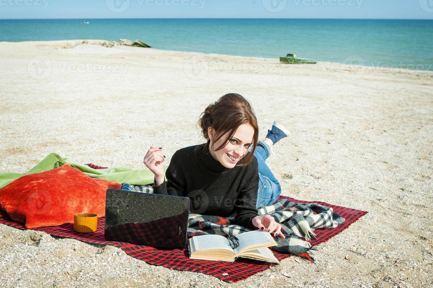 young woman enjoying her working on the beach photo