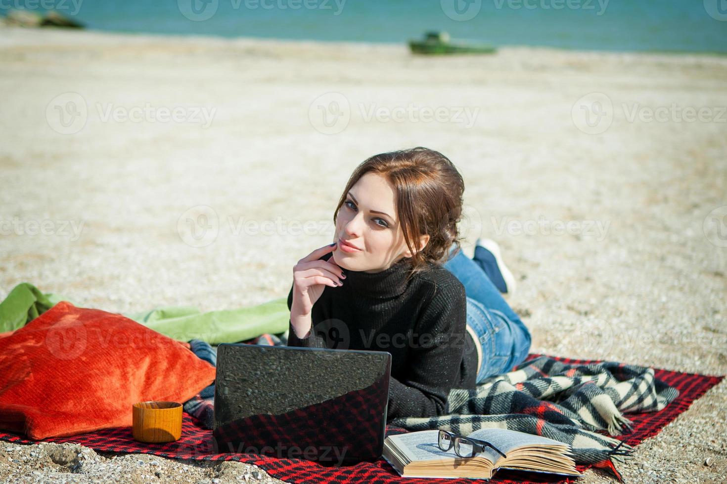 young woman enjoying her working on the beach photo