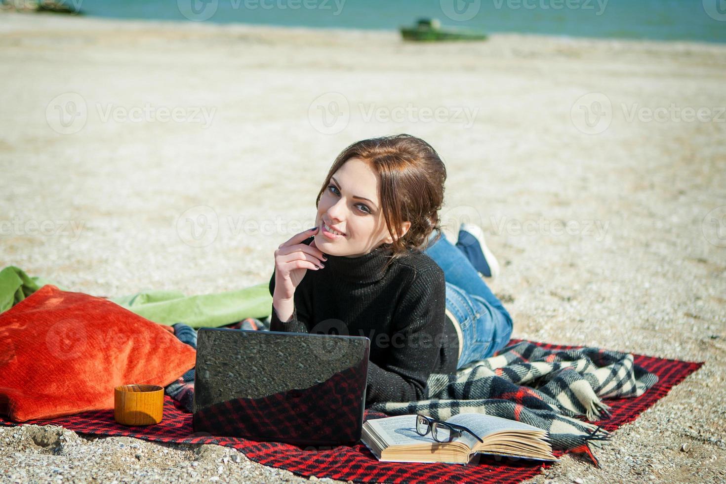 mujer joven disfrutando de su trabajo en la playa foto