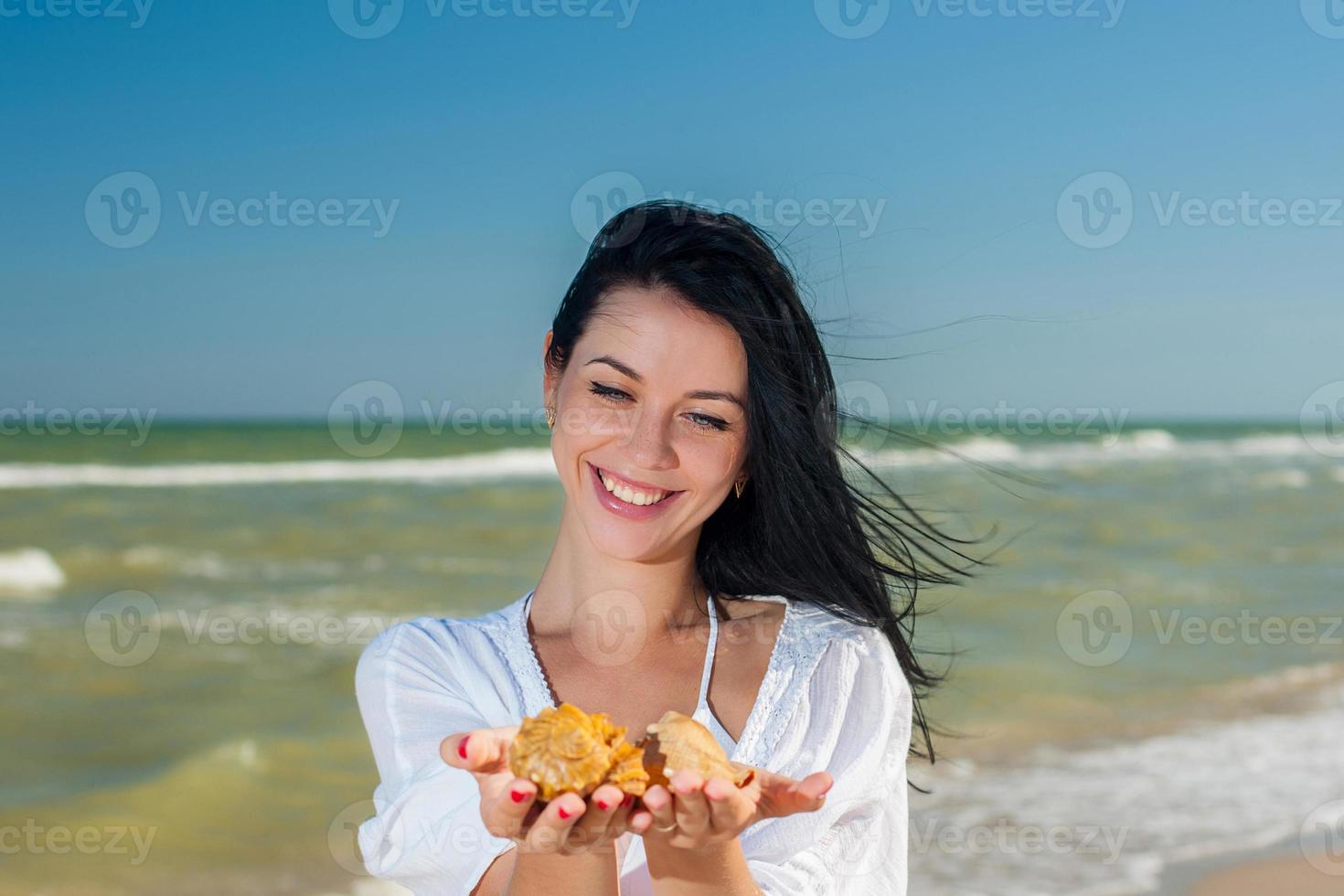 mujer sosteniendo conchas marinas foto