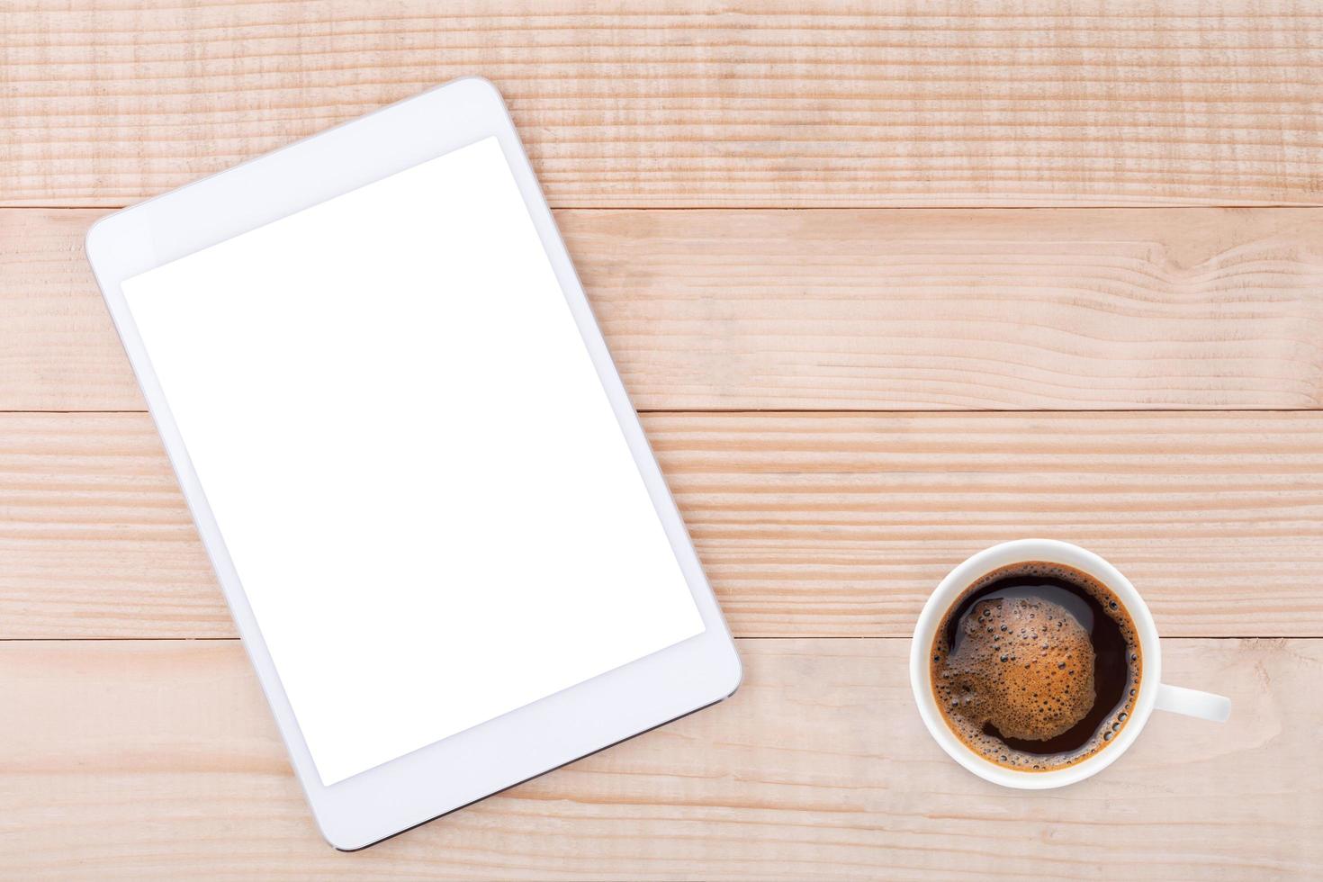 café negro y teléfono móvil o tableta con fondo de madera de maqueta de pantalla en blanco foto