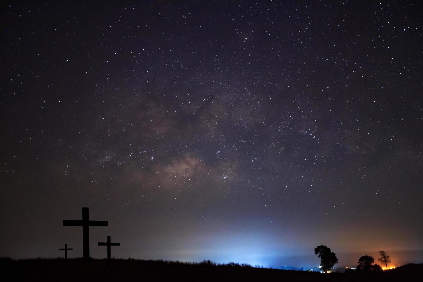 Silhouette of cross over milky way photo