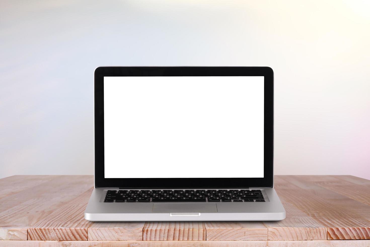 Front view of the laptop is on the work table with bokeh green background photo