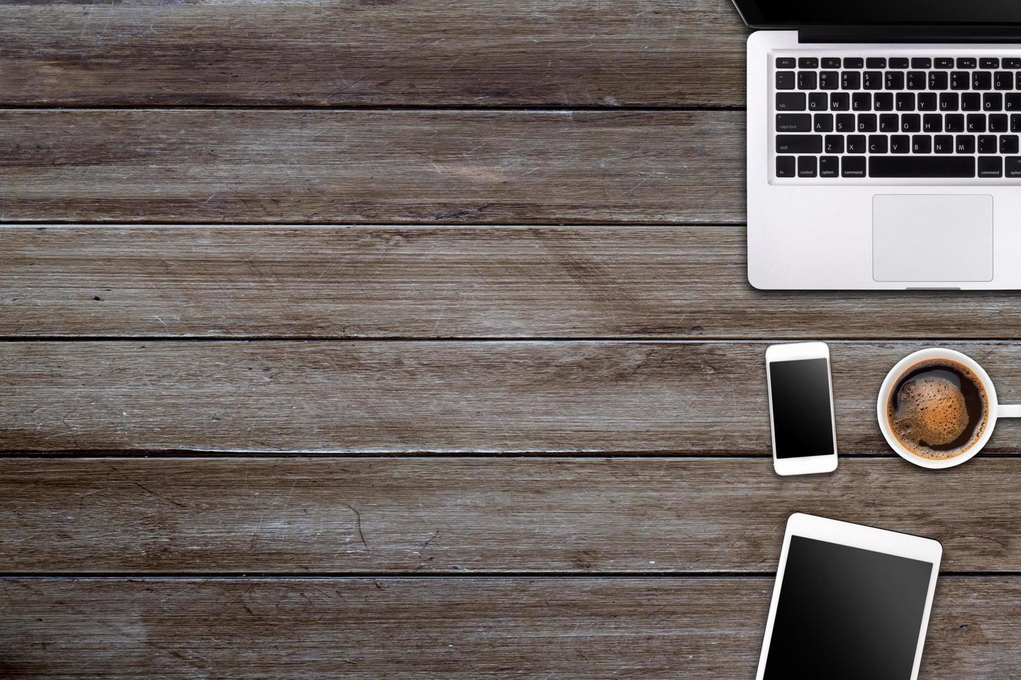 Modern workspace with laptop tablet, smartphone and coffee cup copy space on wood background. Top view. Flat lay style. photo
