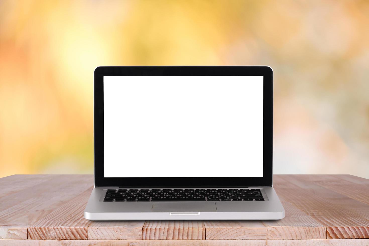 Front view of the laptop is on the work table with bokeh green background photo