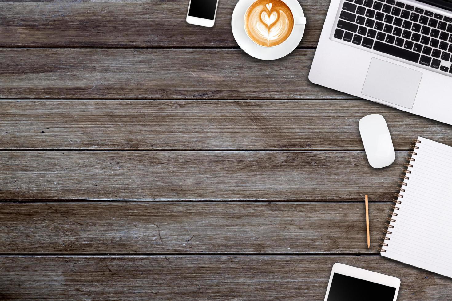 Modern workspace with laptop tablet, smartphone and coffee cup copy space on wood background. Top view. Flat lay style. photo