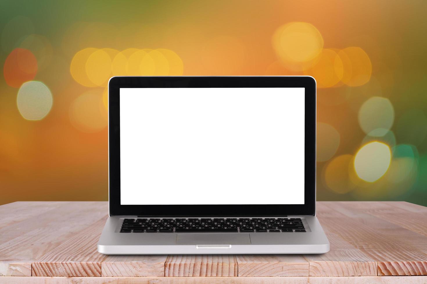 Front view of the laptop is on the work table with bokeh orange background photo