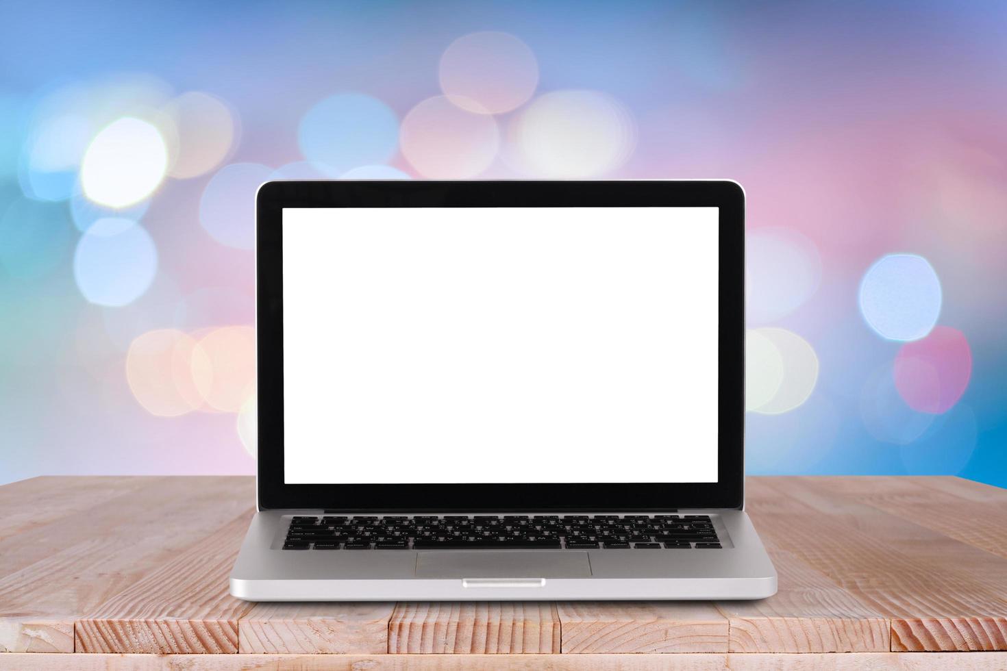 Front view of the laptop is on the work table with bokeh blue background photo