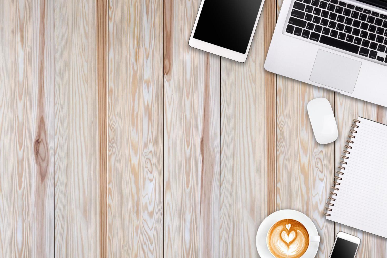 Modern workspace with laptop tablet, smartphone and coffee cup copy space on wood background. Top view. Flat lay style. photo