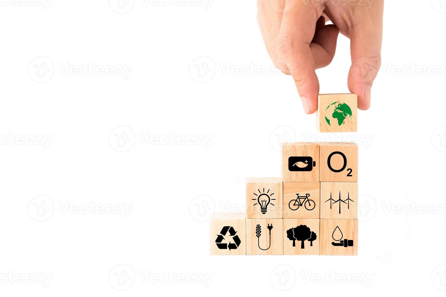 Ideas para salvar el medio ambiente para el día mundial del medio ambiente. mano recogiendo bloques de madera con el icono de la tierra en la parte superior. ahorro de energía, energía limpia, reforestación, aumento de oxígeno, reducción del consumo de combustible. foto