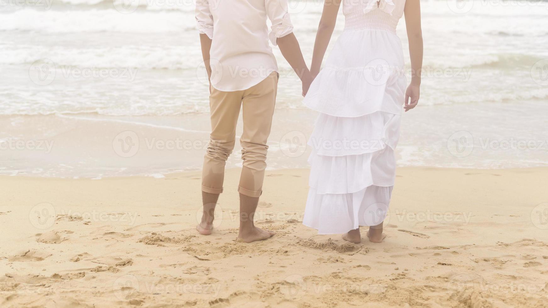 Happy young couple wearing white dress on the beach on holidays, travel, romantic, wedding concept photo