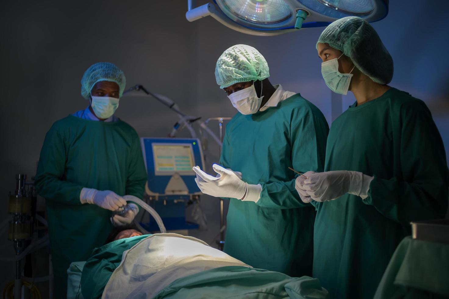 Group of mixed-races professional surgeons operating in hospital operating room , health care concept. photo