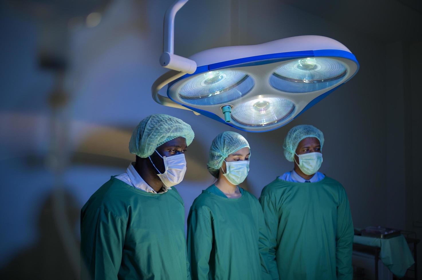Group of mixed-races professional surgeons operating in hospital operating room , health care concept. photo