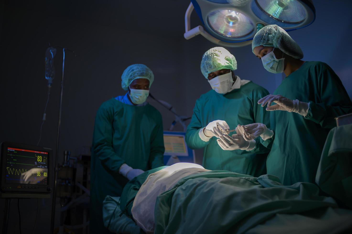 Group of mixed-races professional surgeons operating in hospital operating room , health care concept. photo