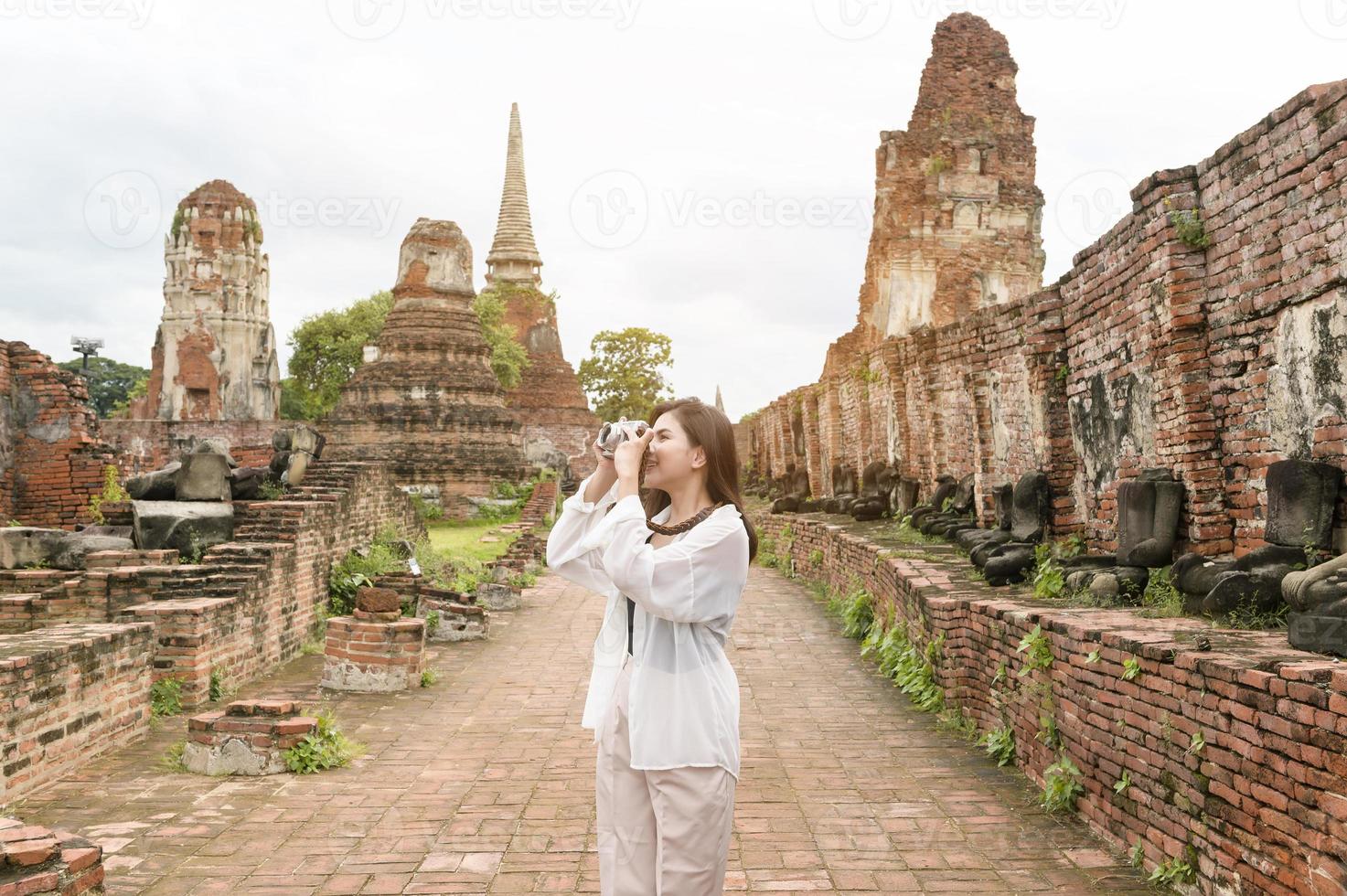 young beautiful woman traveling and taking photo at thai historical Park, Holidays and cultural tourism concept.