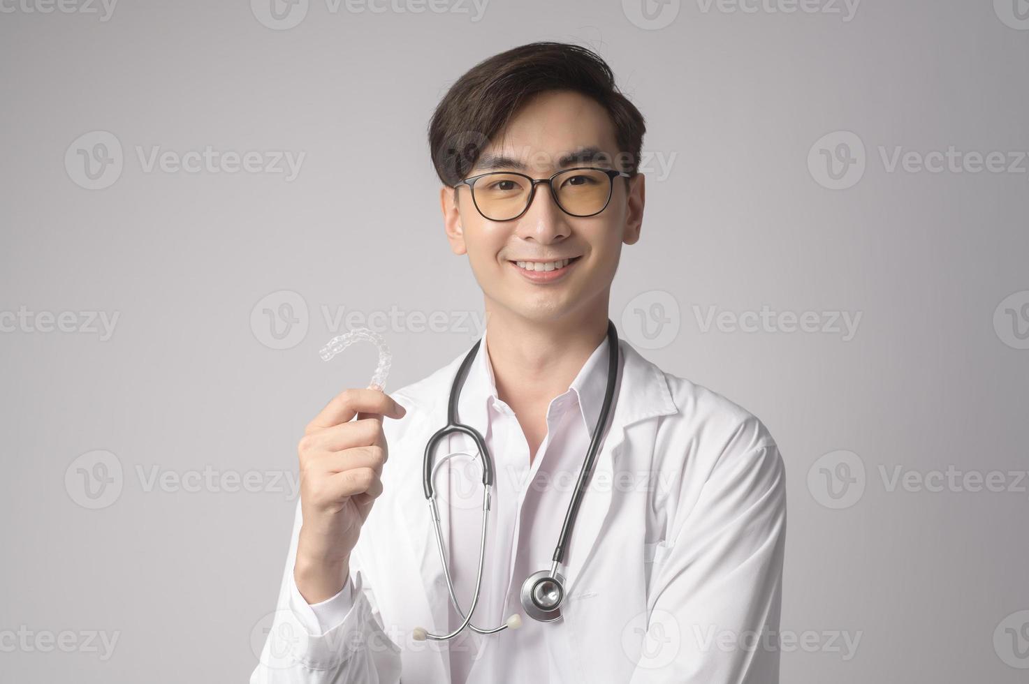 retrato de un médico de confianza masculino sobre un estudio de fondo blanco, concepto de tecnología médica y asistencia sanitaria. foto