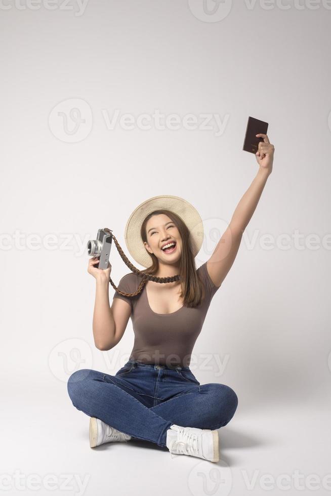 Young happy asian tourist woman over white background studio, travel and holidays concept. photo