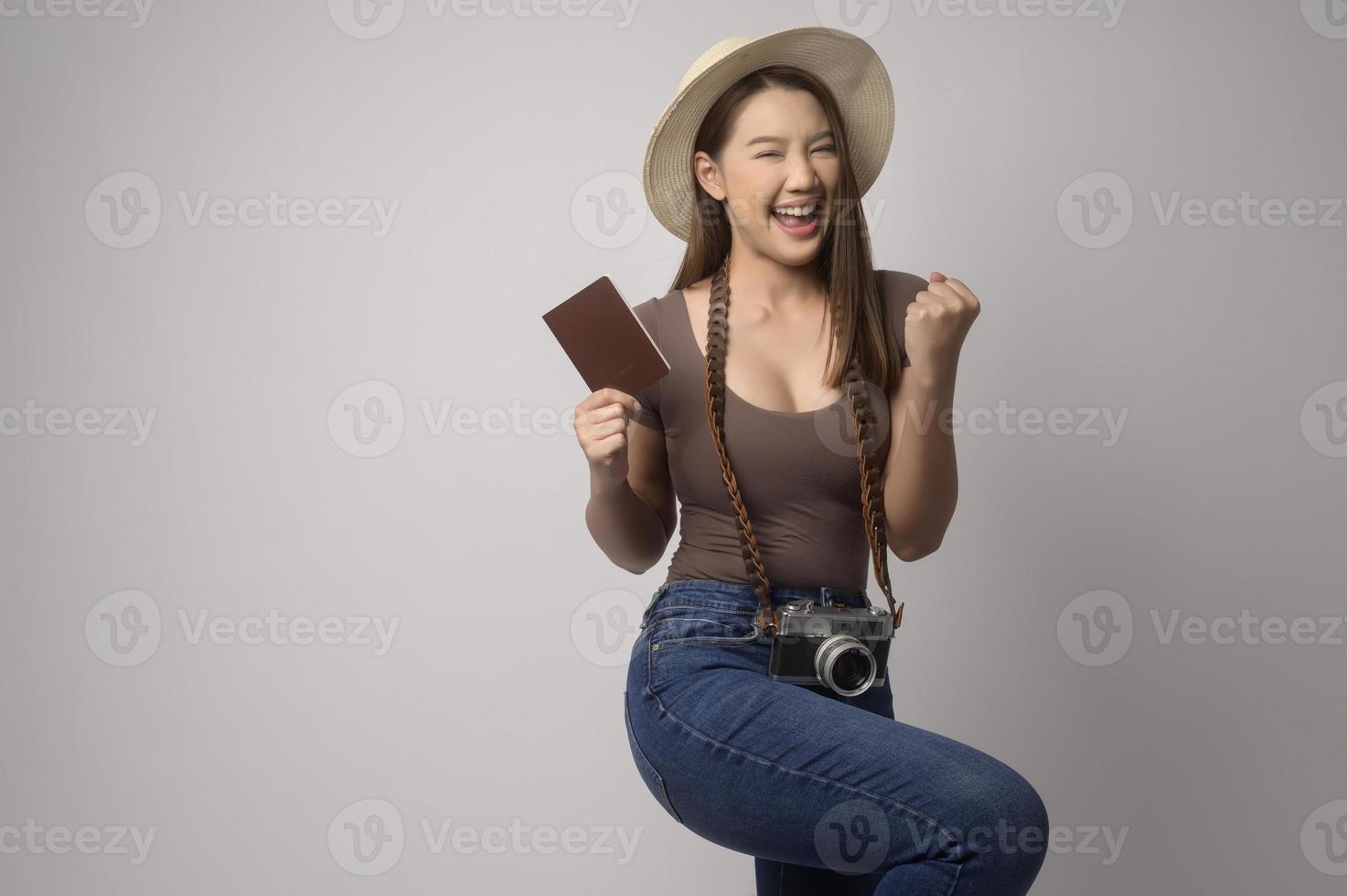 Young happy asian tourist woman over white background studio, travel and holidays concept. photo