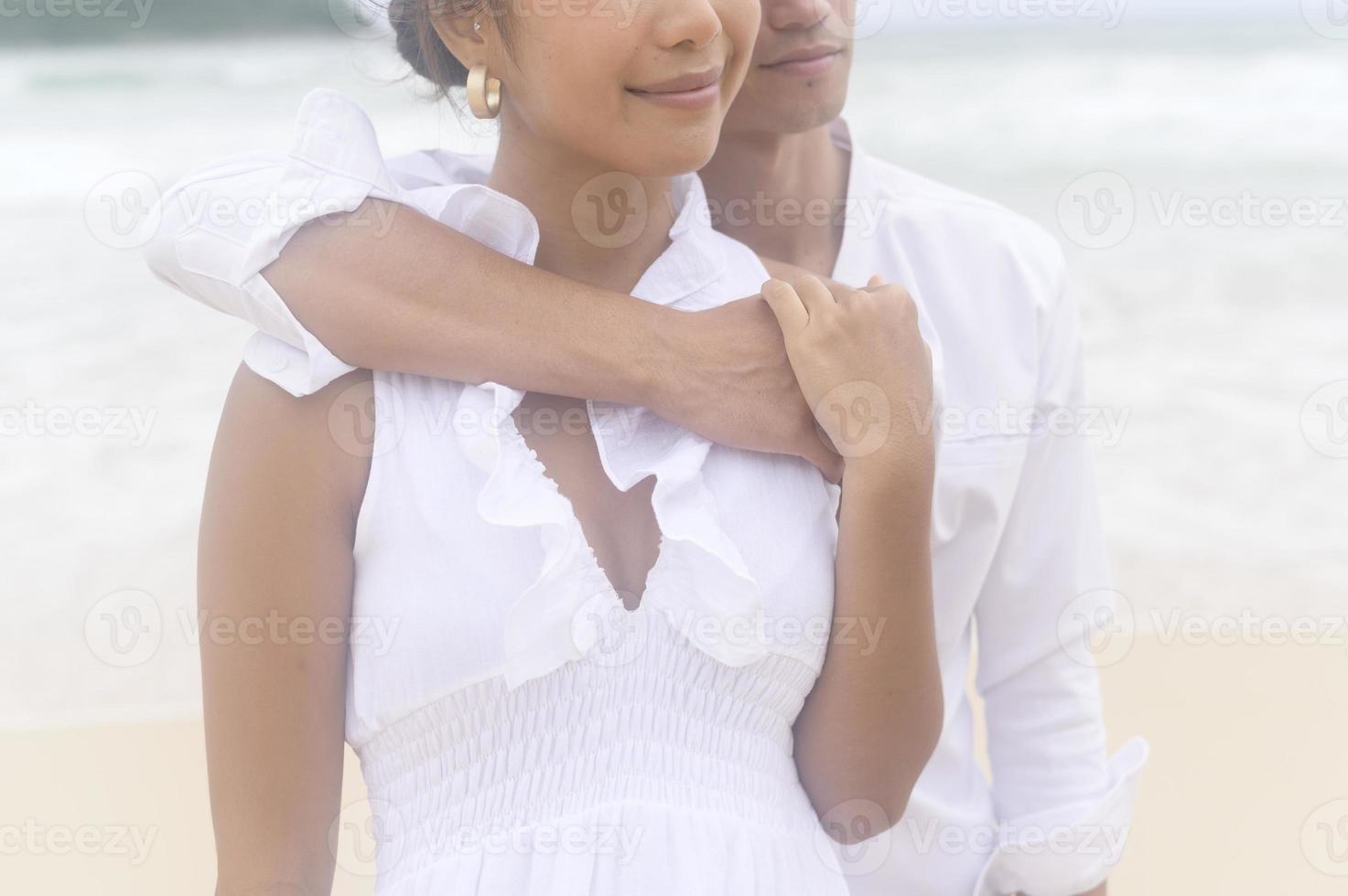 Happy young couple wearing white dress on the beach on holidays, travel, romantic, wedding concept photo