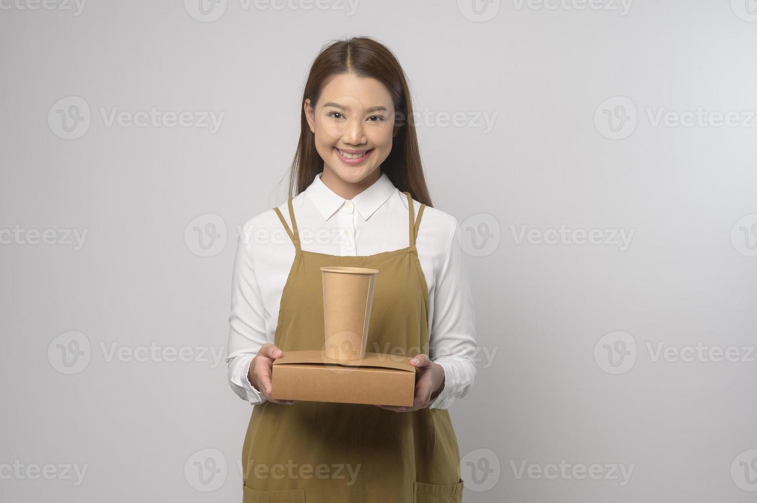 Portrait of young asian woman wearing apron over white background studio, cooking and entrepreneur concept photo