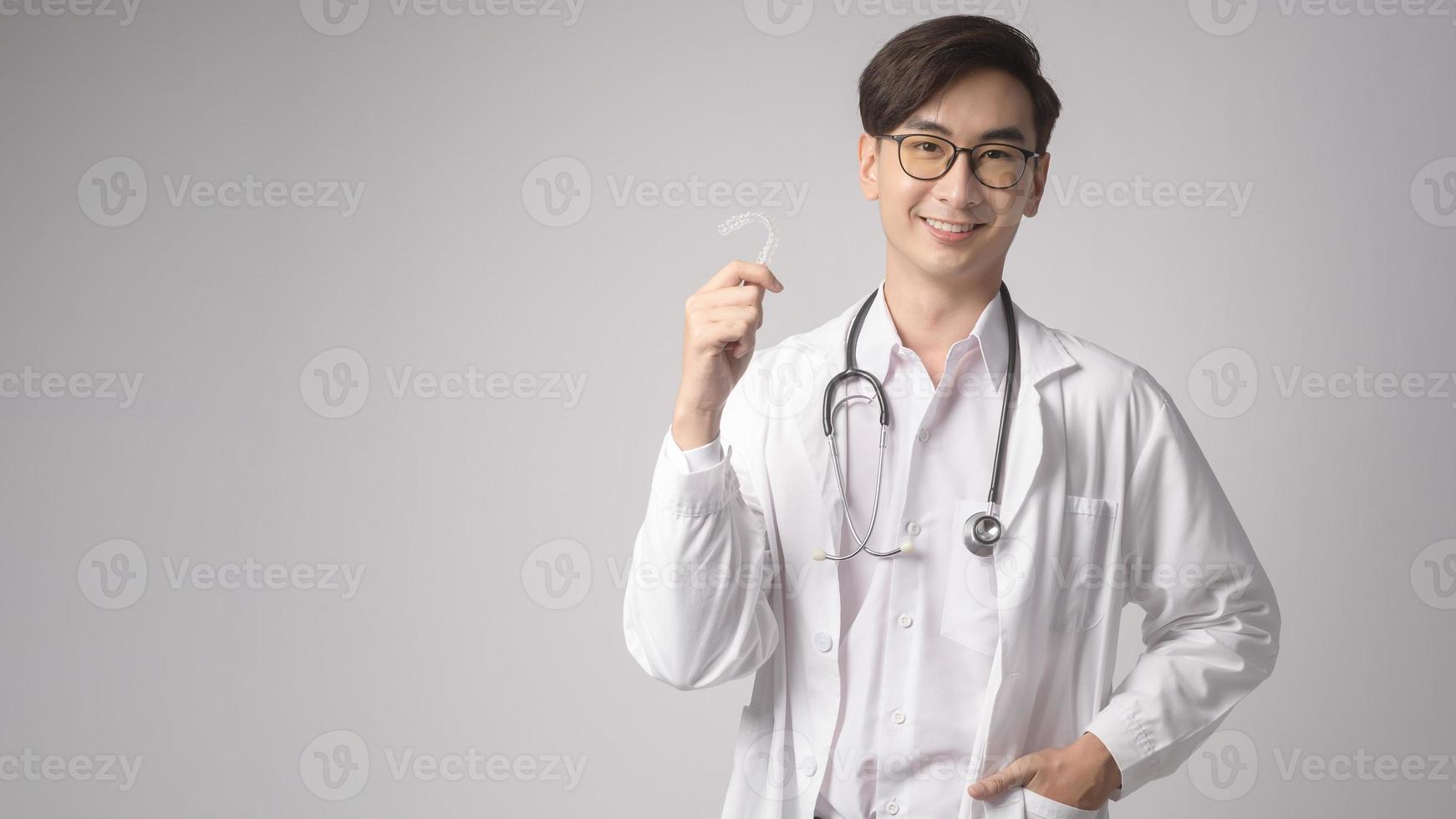 retrato de un médico de confianza masculino sobre un estudio de fondo blanco, concepto de tecnología médica y asistencia sanitaria. foto