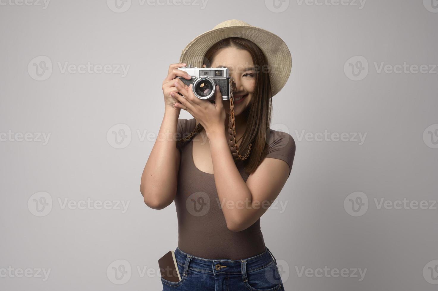 Young happy asian tourist woman over white background studio, travel and holidays concept. photo