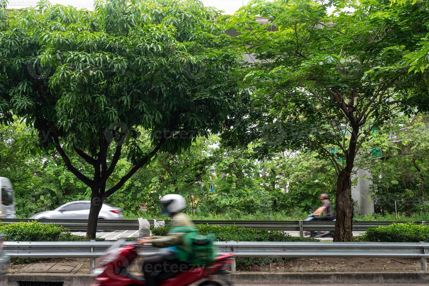 Courier or delivery man on motorbike moving fast, blurred motion. Courier carries out orders for delivery in urban area. photo